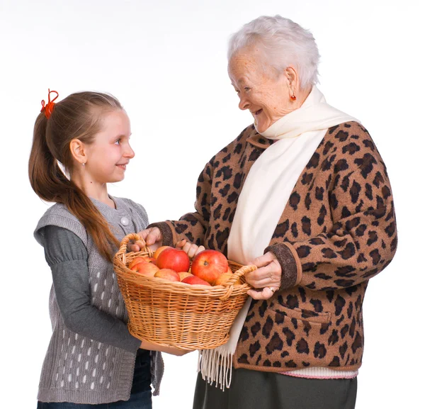 Grandmother with granddaughter with basket of apples — Stock Photo, Image