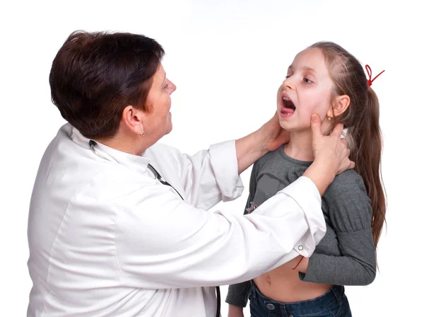 Senior pediatrician examing girl's throat — Stock Photo, Image