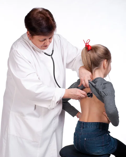 Överläkare lyssnande flicka med stetoskop — Stockfoto