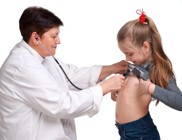 Старший врач слушает девушку со стетоскопом — стоковое фото
