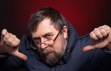 yaşlı adam başparmak aşağı verir.