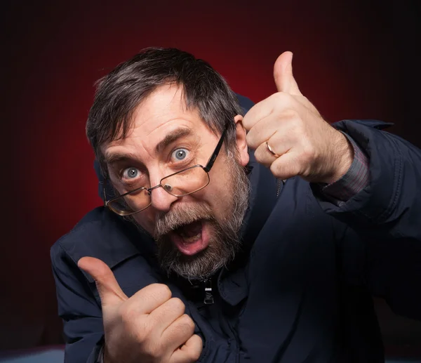 Happy man shows ok sigh on a red — Stock Photo, Image