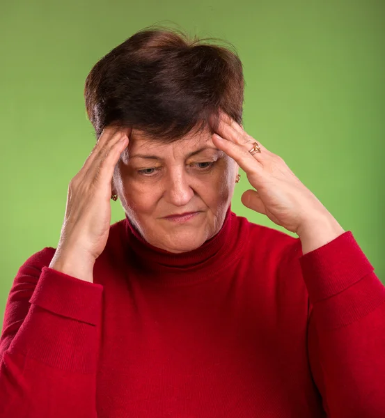 Nadenkend vrouw met haar handen op tempels — Stockfoto