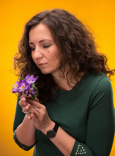 Donna riccia odore di fiori di croco con gli occhi chiusi — Foto Stock