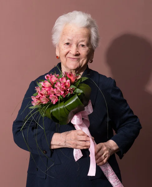Idős nő egy csokor virággal — Stock Fotó