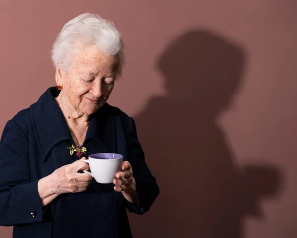 Mulher velha desfrutando de café ou xícara de chá — Fotografia de Stock