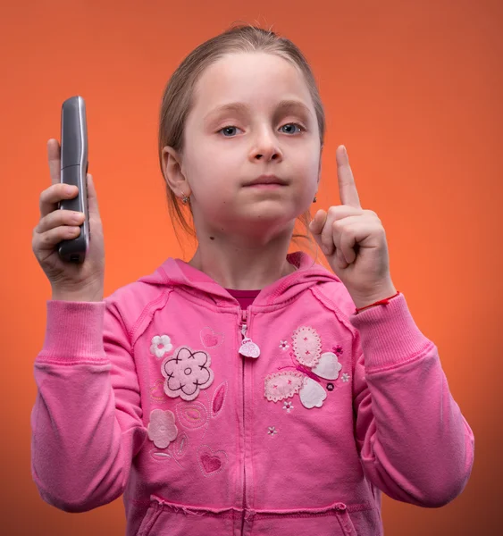 Girl holding a phone and pointing up — Stock Photo, Image