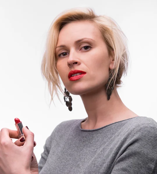 Mooie vrouw aanbrengen lippenstift op haar lippen — Stockfoto