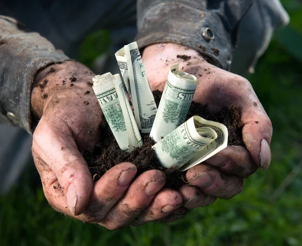 Άνθρωπος εκμετάλλευση χώμα με δολάρια — Φωτογραφία Αρχείου