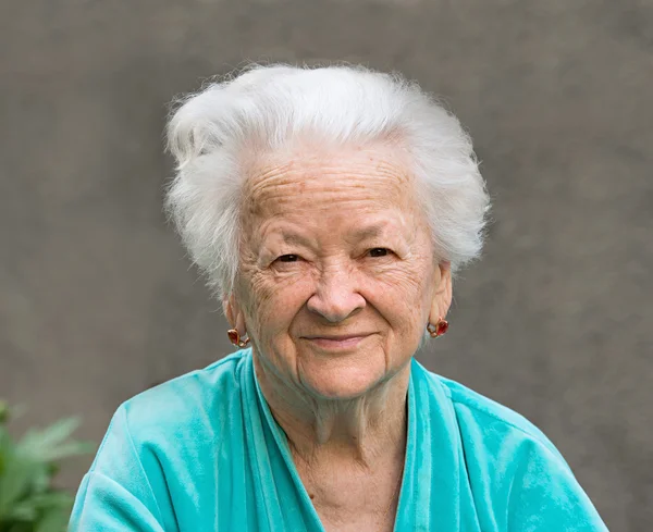 Mujer sonriente sobre un fondo gris — Foto de Stock