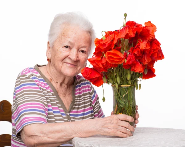 Vieille femme avec un tas de coquelicots — Photo