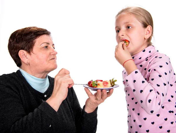 Grootmoeder feeds aardbei op haar kleindochter — Stockfoto
