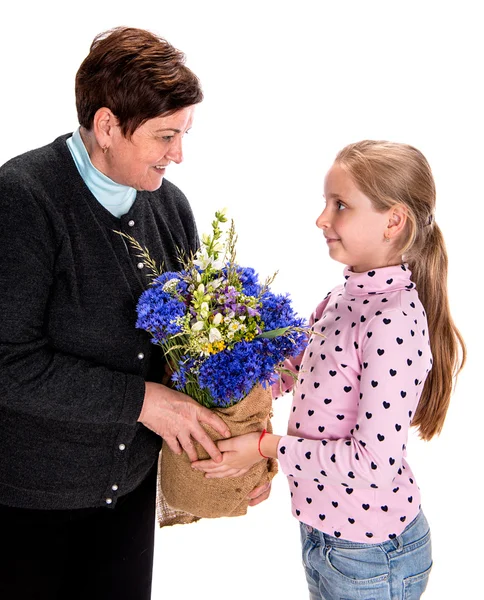 Barnbarn presentera bukett blommor till henne grandmot — Stockfoto