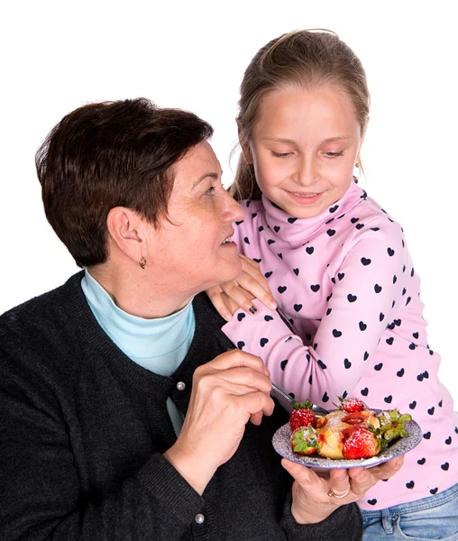Grandmother feeds strawberry pie to her granddaughter — Stock Photo, Image