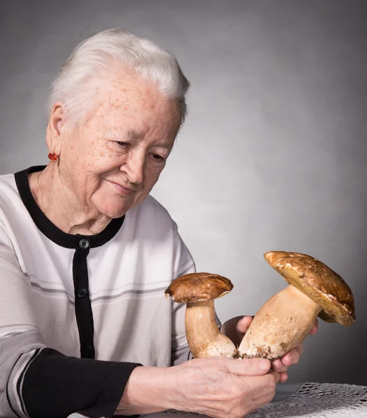 Alte Frau schaut sich Pilze an — Stockfoto