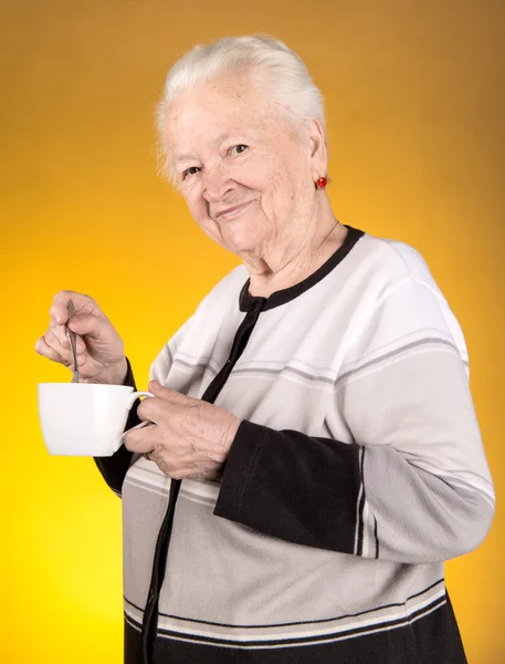 Old woman enjoying coffee or tea cup — Stock Photo, Image