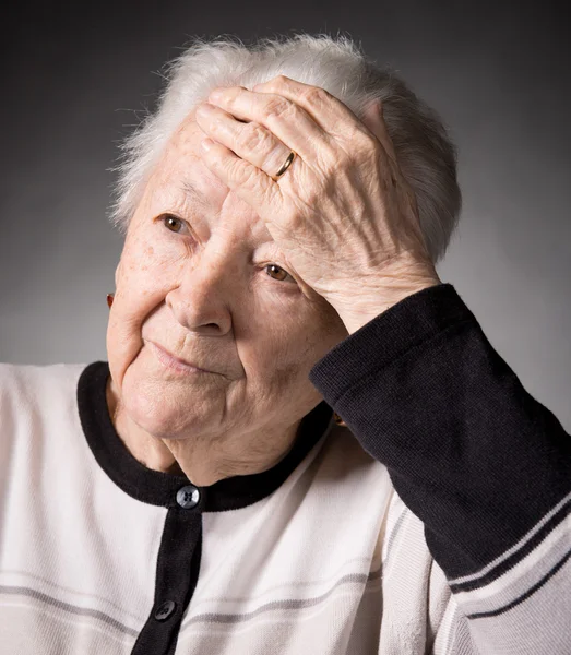 Alte Frau leidet unter Kopfschmerzen — Stockfoto