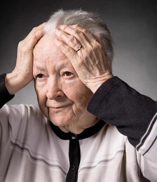 Alte Frau leidet unter Kopfschmerzen — Stockfoto