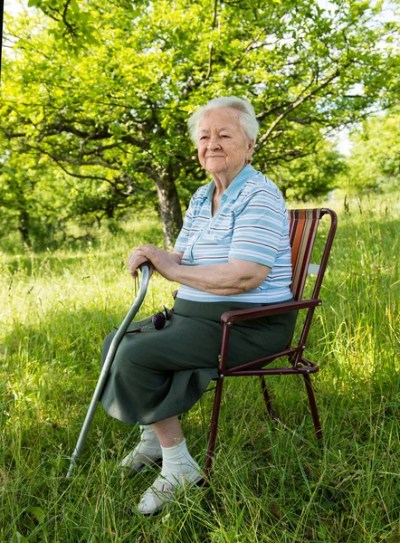 늙은 여자는의 자에 앉아 — 스톡 사진