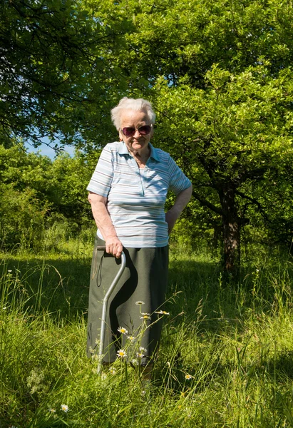 Alte Frau steht mit einem Stock — Stockfoto