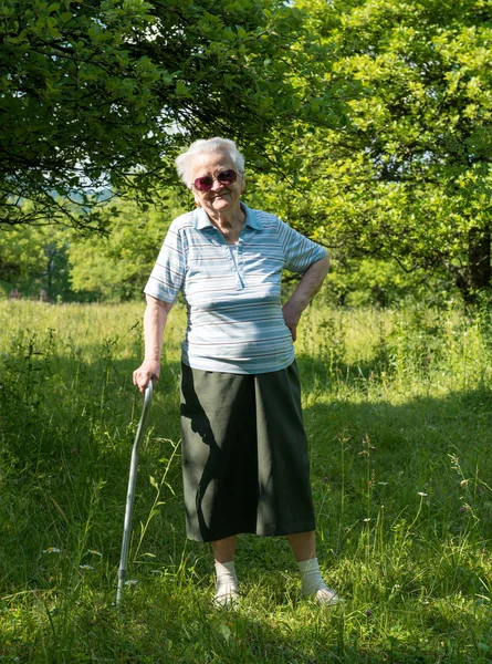 Alte Frau steht mit einem Stock — Stockfoto