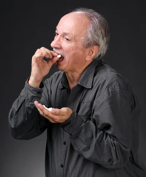 Mann hält Handvoll Pillen in der Hand — Stockfoto
