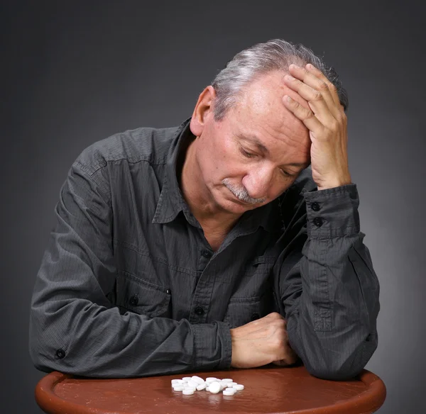 Senior mannen tittar på piller — Stockfoto