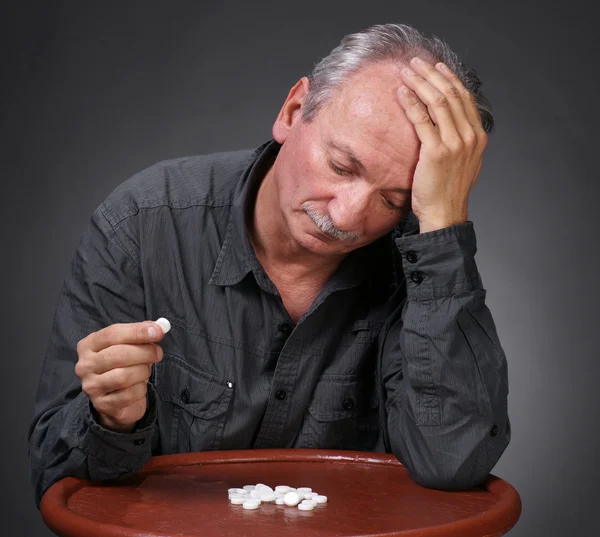 Senior mannen tittar på piller — Stockfoto
