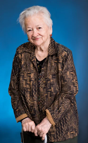 Bastonla ayakta gülümseyen yaşlı kadın — Stok fotoğraf