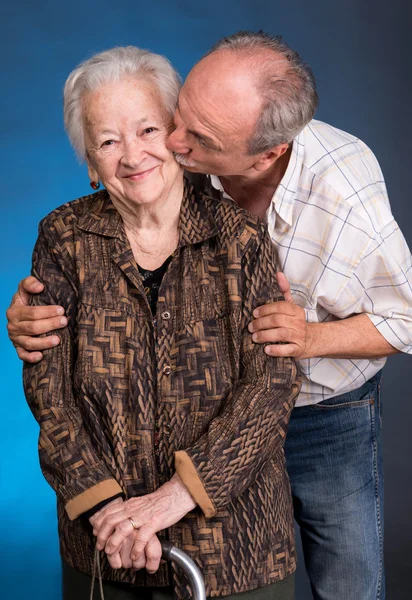 Um filho crescido beijando sua mãe envelhecida — Fotografia de Stock