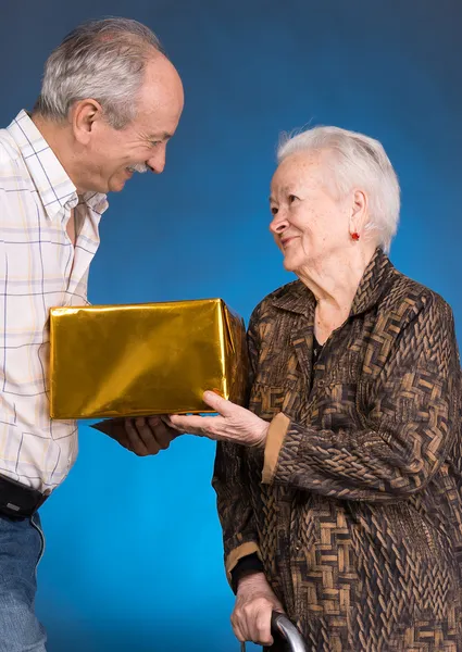 A grown son and aging mom with present box — Stock Photo, Image