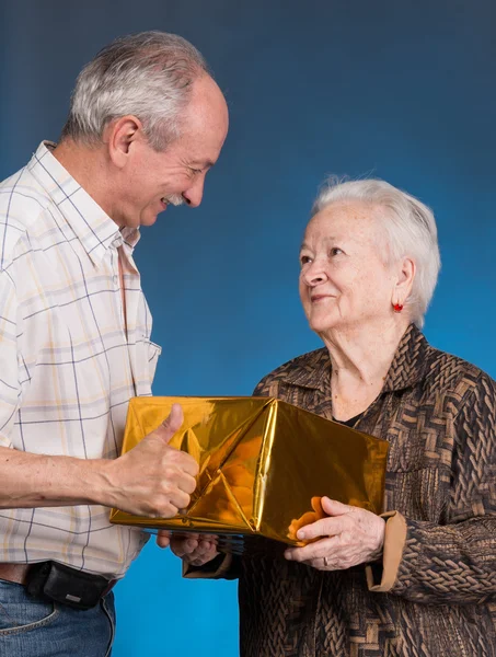 Un figlio adulto e mamma anziana con scatola regalo — Foto Stock