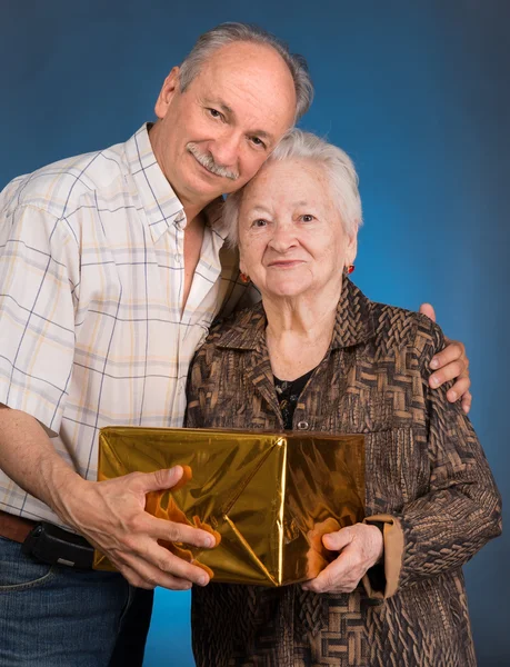 En vuxen son och åldrande mamma med nuvarande låda — Stockfoto