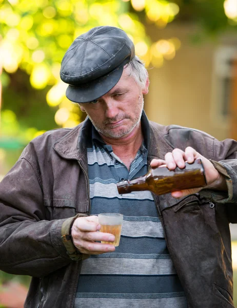 Opilý muž s lahví piva a skla — Stock fotografie