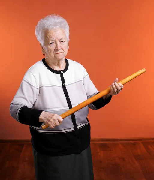 Vieja mujer enojada amenazando con un rodillo — Foto de Stock