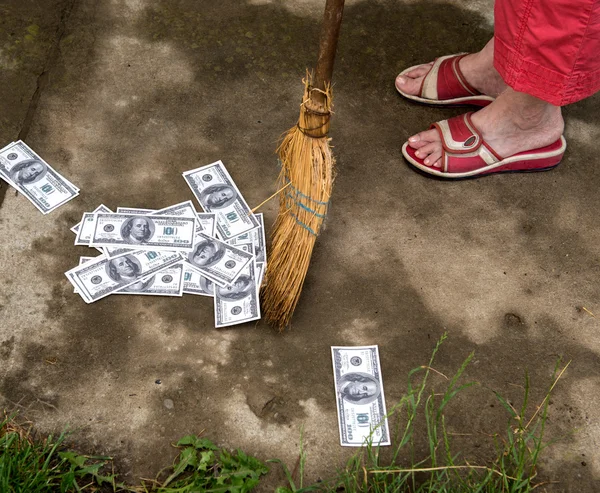 Woman sweeping dollars — Stock Photo, Image