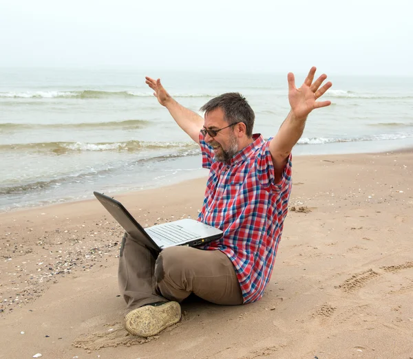 Emotional businessman with laptop on the beach — Stock Photo, Image