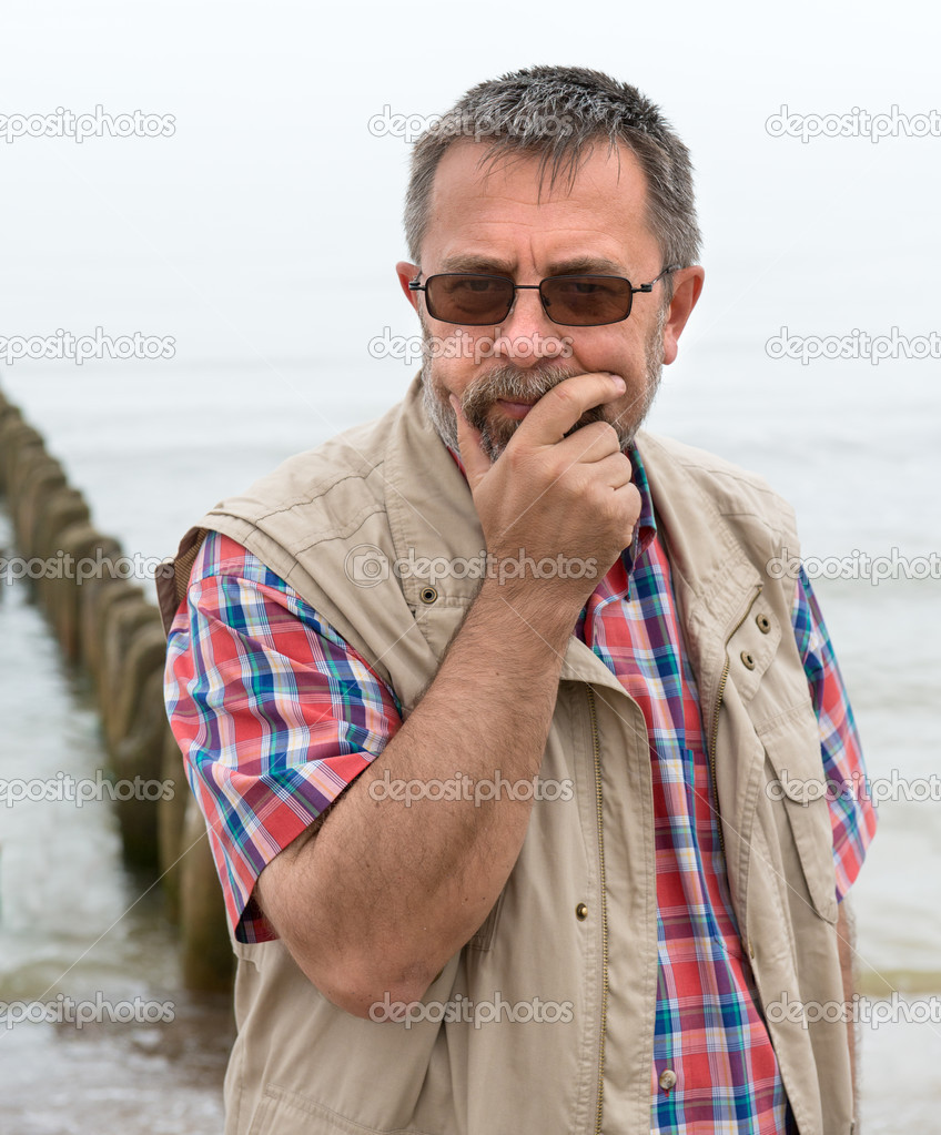 Sad looking elderly man on the beach