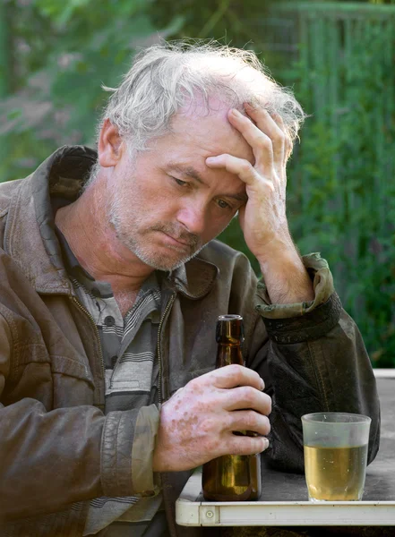 Hombre borracho con botella de cerveza y vidrio — Foto de Stock