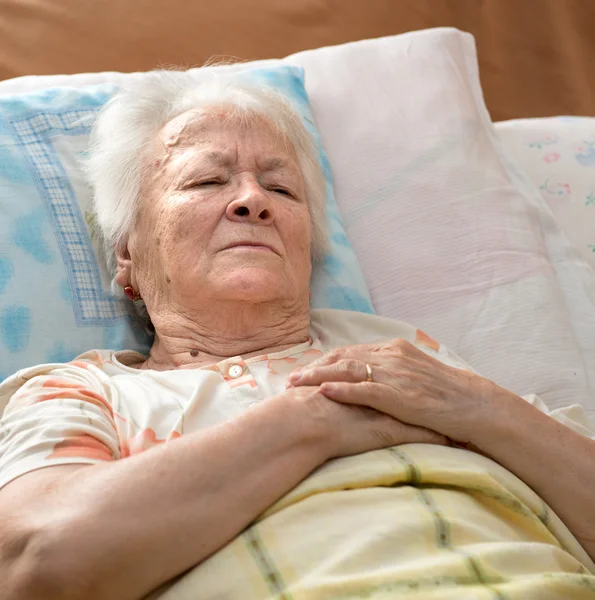 Senior vrouw liggen op bed — Stockfoto