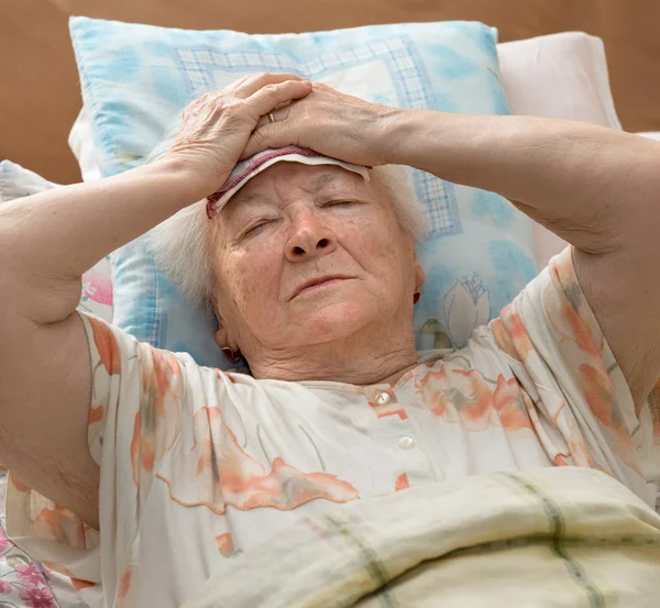 Senior woman lying at bed — Stock Photo, Image