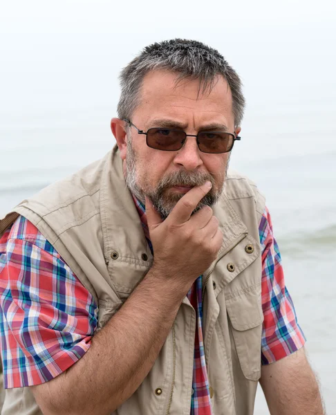 Sad söker äldre man på stranden — Stockfoto