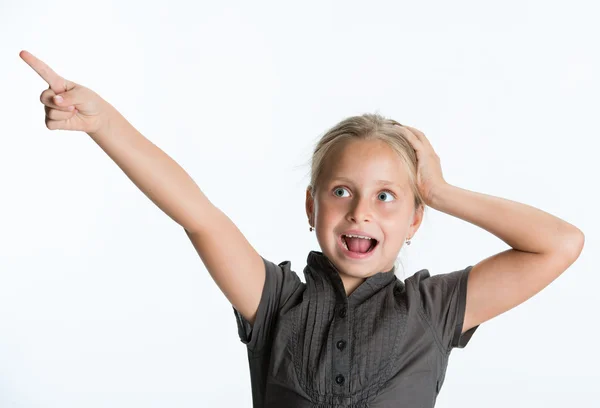 Kleines Mädchen zeigt mit dem Finger auf weißem Hintergrund. — Stockfoto