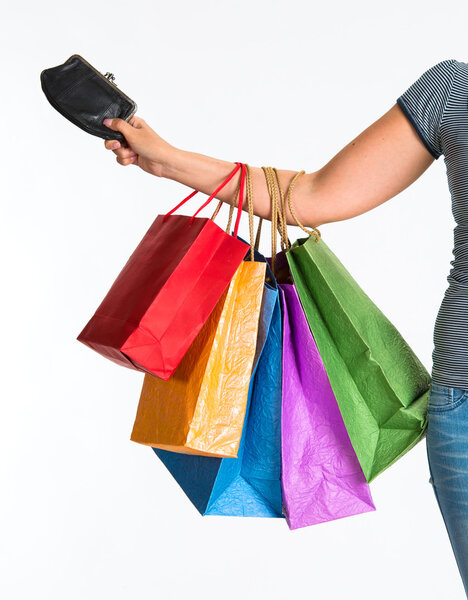 Female hand holding shopping bags and purse