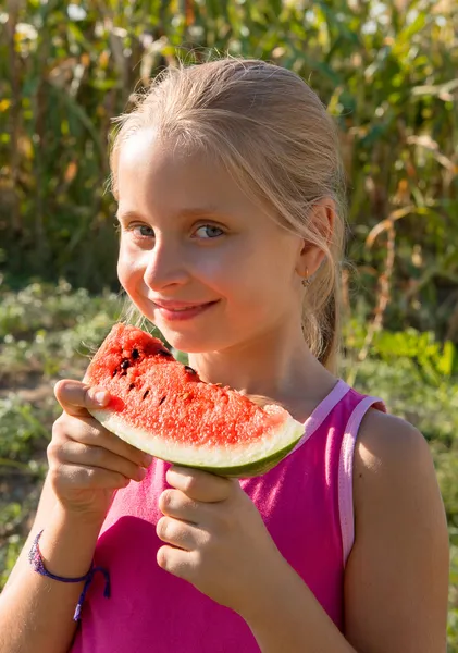 Klein meisje proeverij watermeloen — Stockfoto