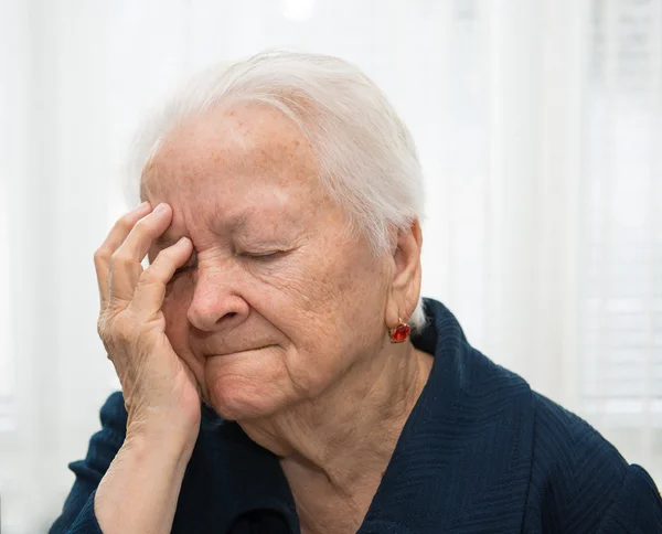 Mulher idosa que sofre de dor de cabeça — Fotografia de Stock