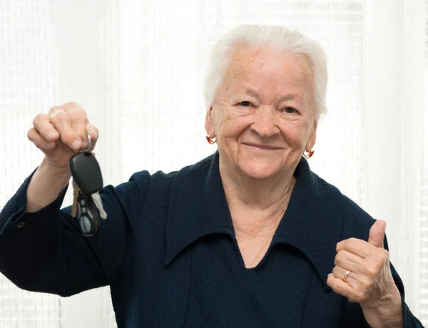 Senior woman with a car key and making OK gesture — Stock Photo, Image