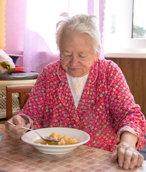 Äldre kvinna äta soppa — Stockfoto