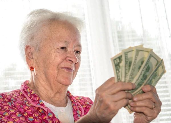 Old woman holding money in hands — Stock Photo, Image