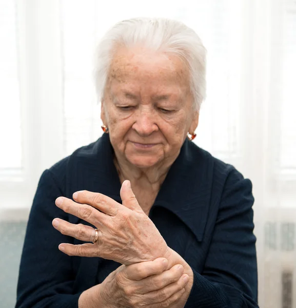 Äldre kvinna mäter sin puls — Stockfoto